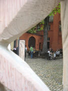 Blick zum Cafe Mas y Mas am Adelhauser Klosterplatz durch eine Holzstele